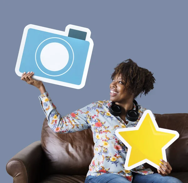 Donna Allegra Mostrando Icona Della Fotocamera Blu Sul Divano — Foto Stock