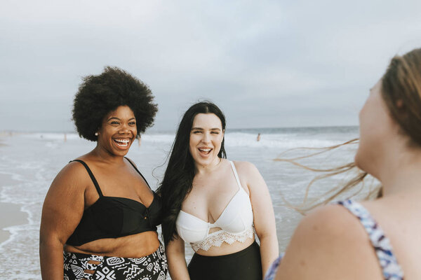 Cheerful beautiful plus size women at the beach