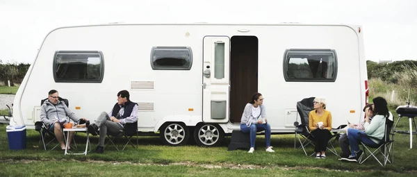 Group of people sitting outside a trailer park