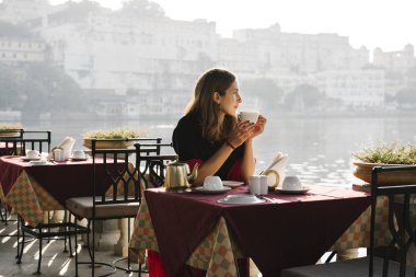 Batılı kadın Udaipur 'da bir kafede çay içiyor.