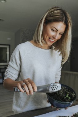 Kızarmış kale ve nohut hizmet veren kadın
