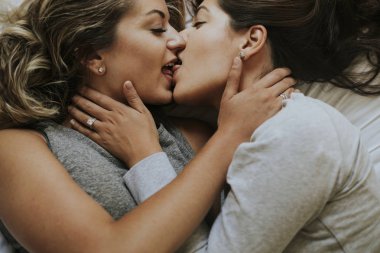 Lesbian couple kissing in the morning clipart