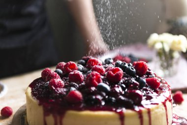 Karışık Meyveli cheesecake ile beyaz toz serpilir