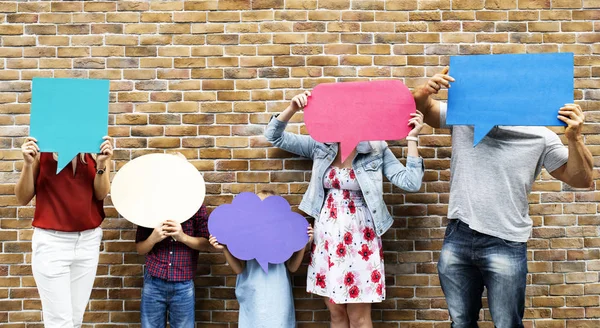 Familia Sosteniendo Blanco Burbujas Habla Colores Por Una Pared Ladrillo — Foto de Stock