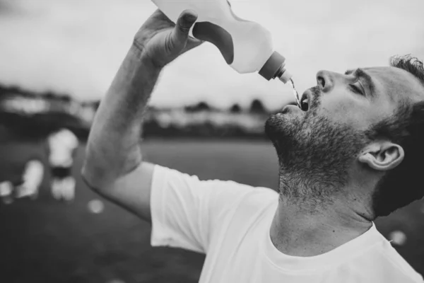 足球教练在足球比赛后喝水 — 图库照片