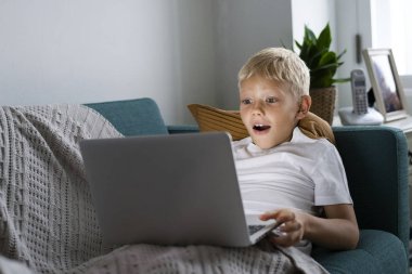 Genç oğlan izlerken videolar üzerinde onun laptop