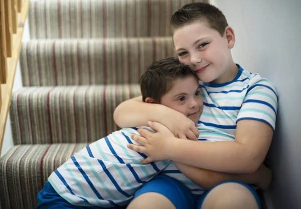 Brothers hugging at the stairs