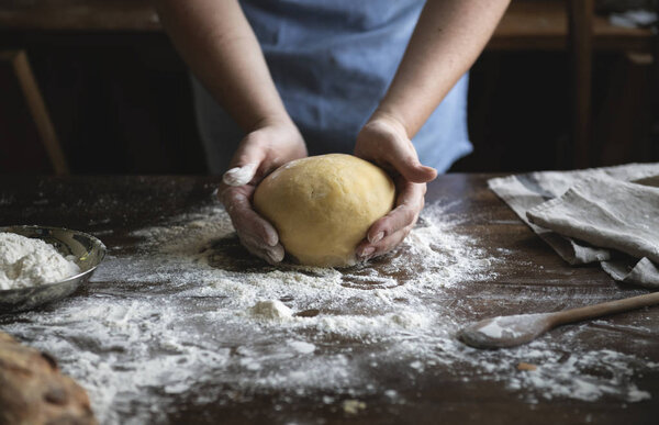 Baker preparing dough on a wooden table