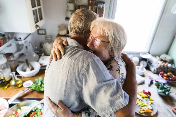 欢快的老年人在厨房里拥抱 — 图库照片
