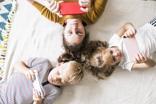 Kids Lying Floor Playing Games Phones — Stock Photo, Image