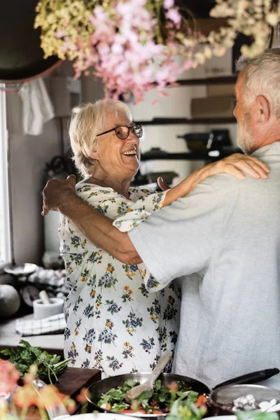 欢快的老年夫妇在厨房拥抱 — 图库照片#