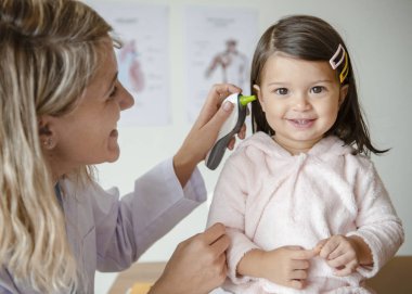Otolaryngologist tatlı küçük bir kız üzerinde kontrol