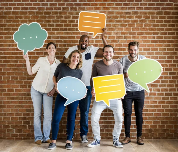 Diverse happy people holding speech bubble icons