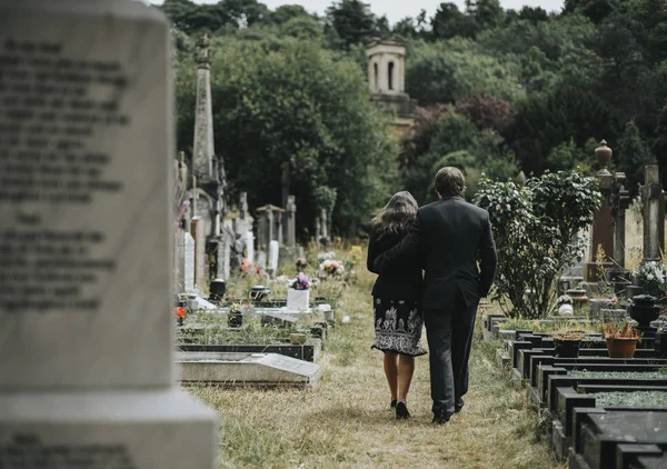 Bir mezarlıkta yürüyen üzgün çift