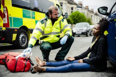 Erkek Sağlık görevlisi bir yolda yaralı bir kadın kontrol