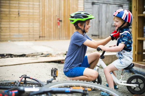 Niño Ayudando Hermano Ponerse Casco —  Fotos de Stock