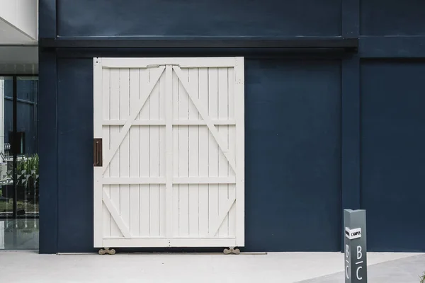 蓝色建筑墙上的木白色门 — 图库照片