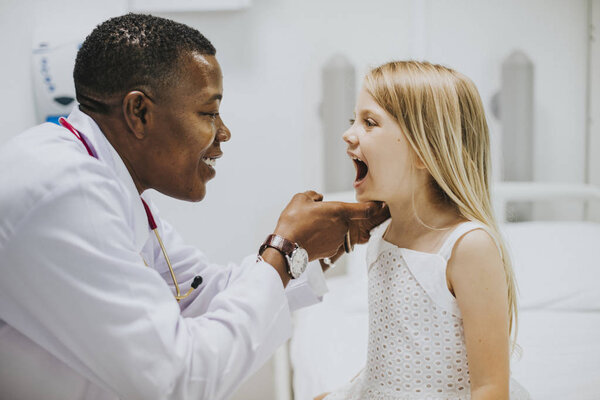Young girl showing a dentist her teeth