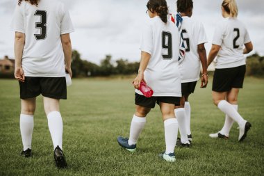 Genç kadın futbol oyuncular bir alanda yürüyüş