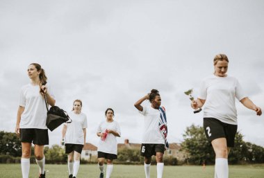 Genç kadın futbol oyuncular bir alanda yürüyüş