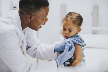 Toddler bir çocuk doktoru tarafından aşı oluyor
