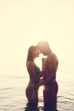 Gün batımında denizde romantik bir çift