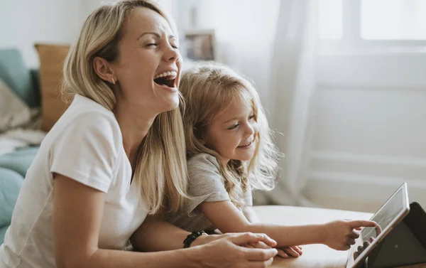 Mom and daughter watching a cartoon on a digital tablet