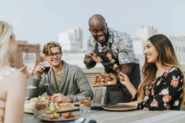 Cheerful chef serving grilled vegan barbeque skewers