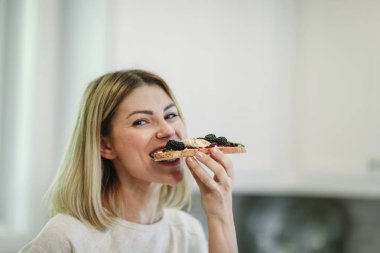Peynirli bir tost ile böğürtlen reçeli ve vegan olan kadın krem