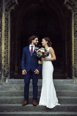 Yeni evli çift kilise merdivenlerinde