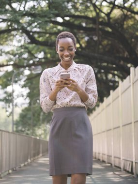 Siyah bayan parkta yürürken telefonuna mesaj