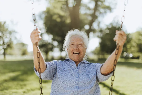 Fröhliche Seniorin Auf Schaukel Auf Spielplatz — Stockfoto