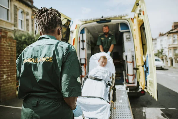 Sağlık Görevlileri Genç Bir Hastaya Ambulans Bir Sedyeye Taşıma — Stok fotoğraf