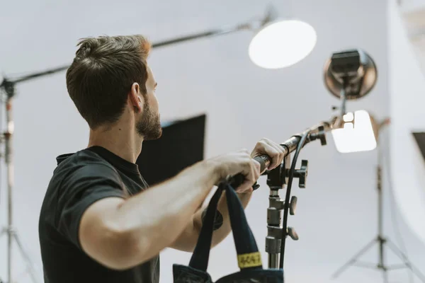 Jovem Ajustando Luz Estúdio — Fotografia de Stock