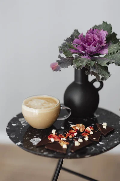 Dark chocolate brittle and milk tea on a black table with an ornamental kale flower — Stock Image Dark Chocolate Brittle Milk Tea Black Table Ornamental Kale Flower Royalty Free Stock Photos