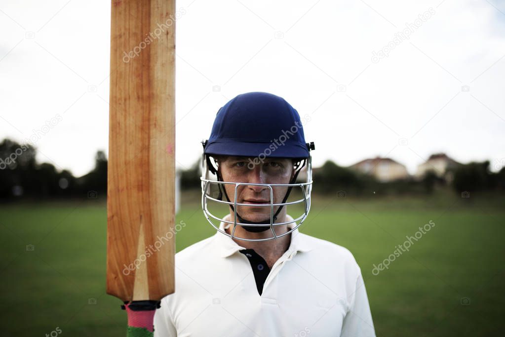 Cricket player holding a bat on the field