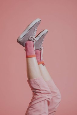 Pembe pantolonlu kadın bacakları havada.