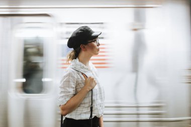 Metro platformunda tren bekleyen düşünceli kadın