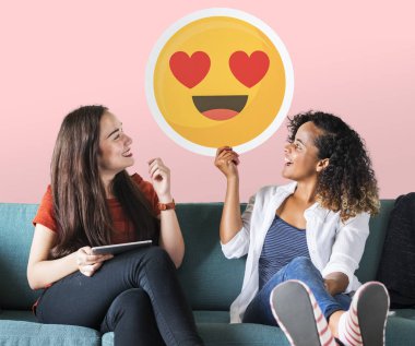 Neşeli kadın kalp gözleri ifade simgesi tutan