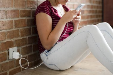 Pilin şarj edilmesi sırasında telefonunu kullanan genç kız