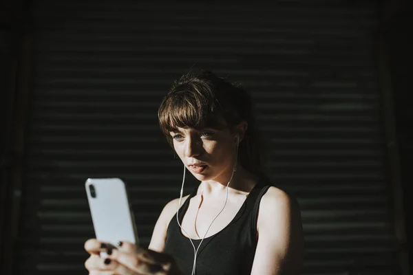 Sportliche Frau Hört Musik Einer Dunklen Gasse — Stockfoto