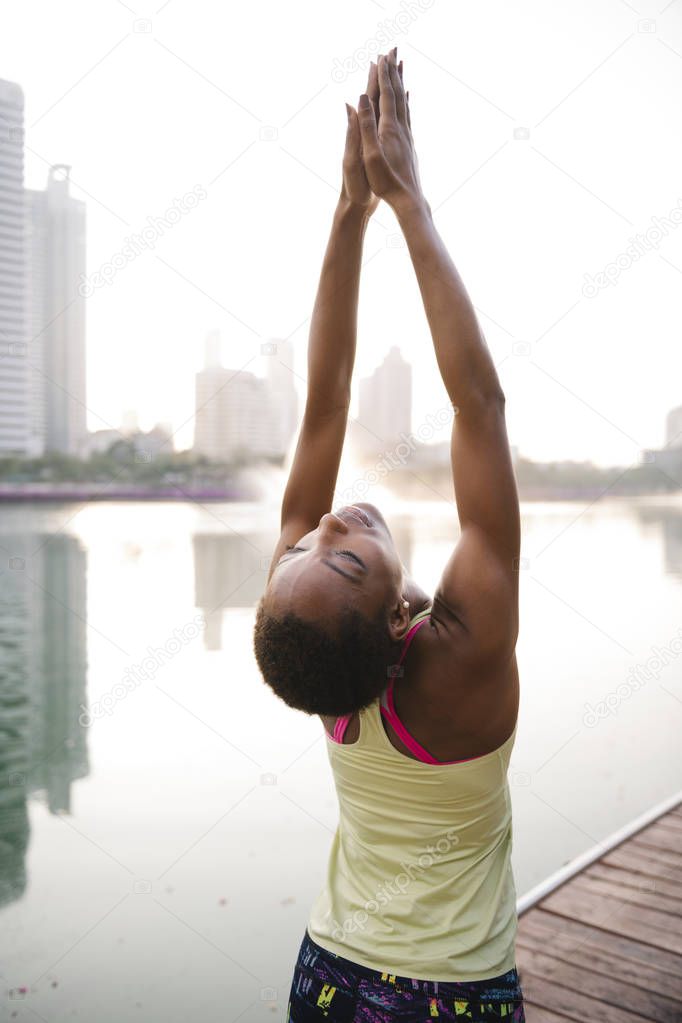 Black lady doing a yoga in a park