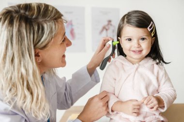 Otolaryngologist tatlı küçük bir kız üzerinde kontrol