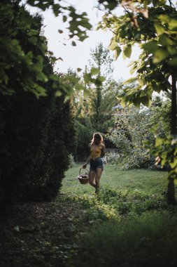 Çimenlerde yalın ayak yürüyen bir kadın.