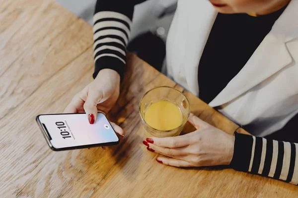 Frau Trinkt Ein Glas Saft Und Checkt Ihr Handy — Stockfoto