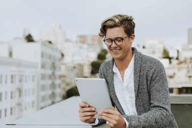 San Francisco'da bir çatı, dijital tablet kullanan adam