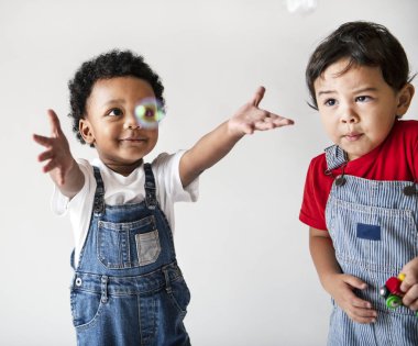 Two cute little boys enjoying playing with bubbles clipart