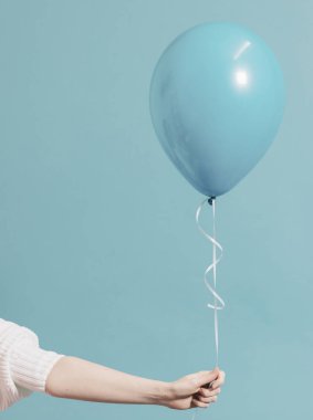 Pastel mavi balon tutan kız