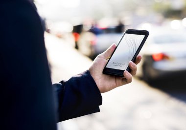 Bir akıllı telefon ile bir ekran mockup kullanan kadın