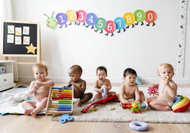 Babies playing together in a play room clipart